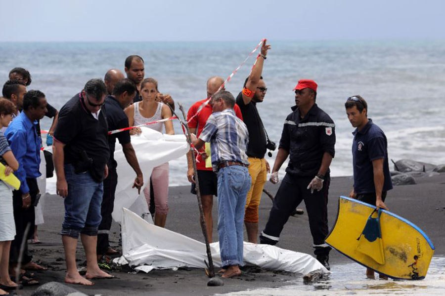 Autoridades locais tapam o corpo do jovem na praia.