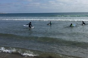 Famila encontrava-se na berma da água em que o pai estava a ensinar os flhos a fazer surf