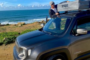 Cris prepara o Jeep e a sua Topo Tent junto a uma praia onde quebravam boas ondas.