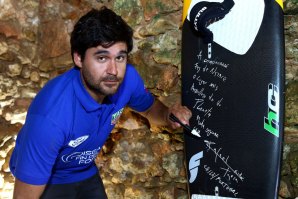 Rafael Tapia no momento em que oferece a sua prancha à Surfer Wall.